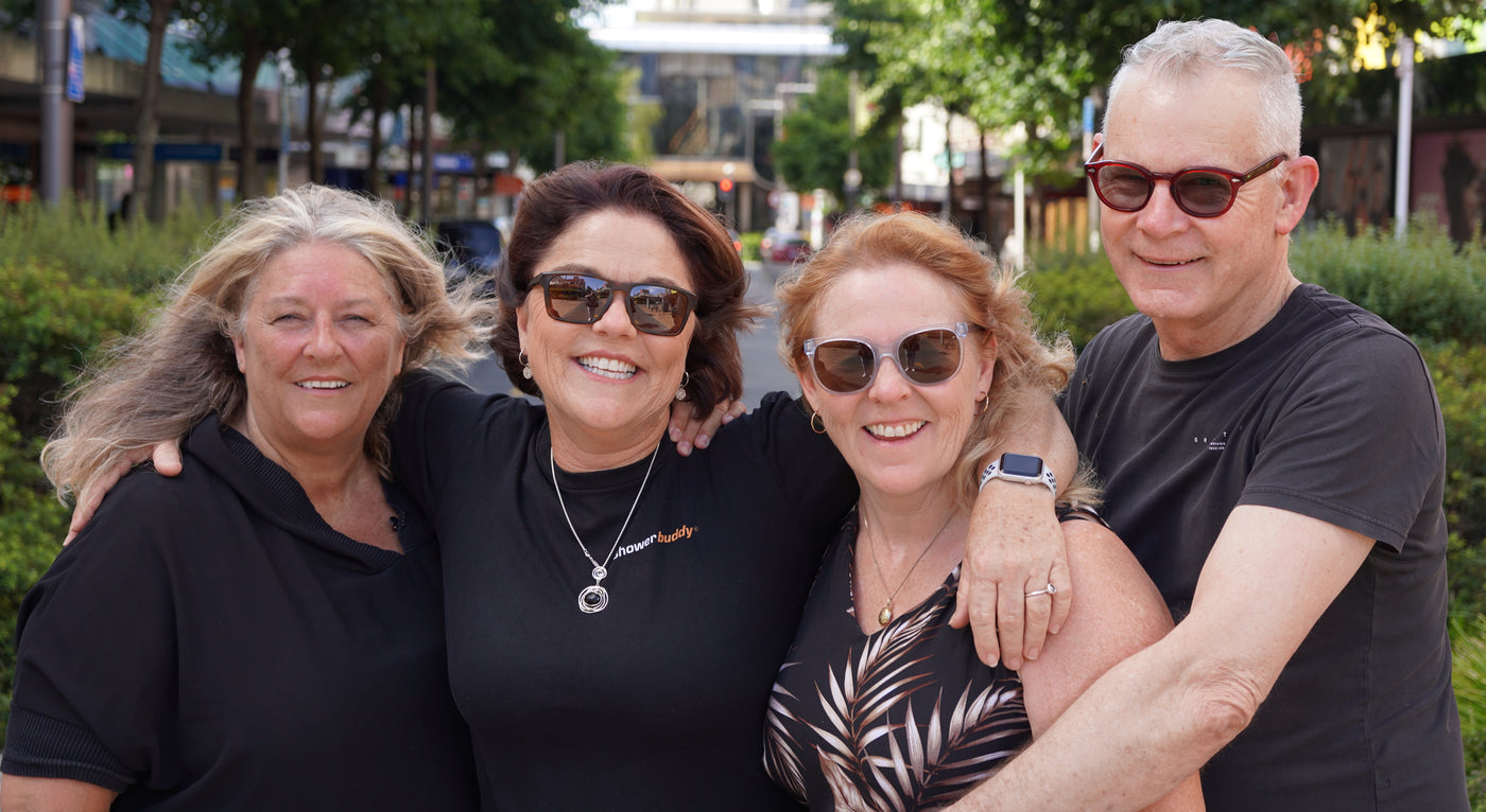 Group of happy Showerbuddy team members outdoors, showcasing the supportive community behind the company's commitment to enhancing bathroom mobility for those with accessibility needs.